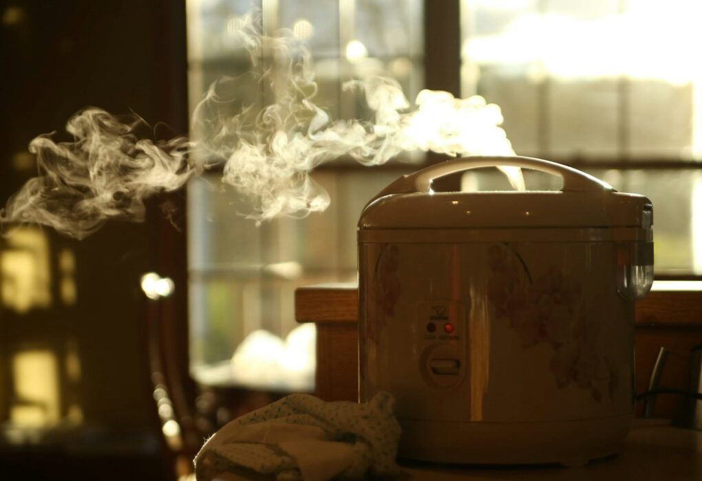 Rice cooker putih di atas meja dapur mungil