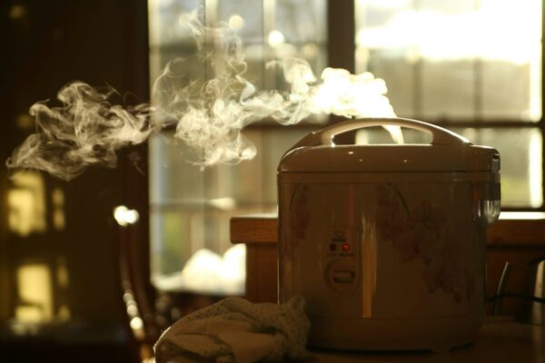 Rice cooker putih di atas meja dapur mungil